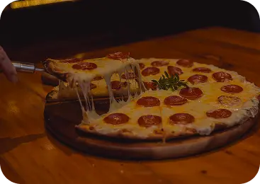 Chef taking a freshly baked pizza out of the oven