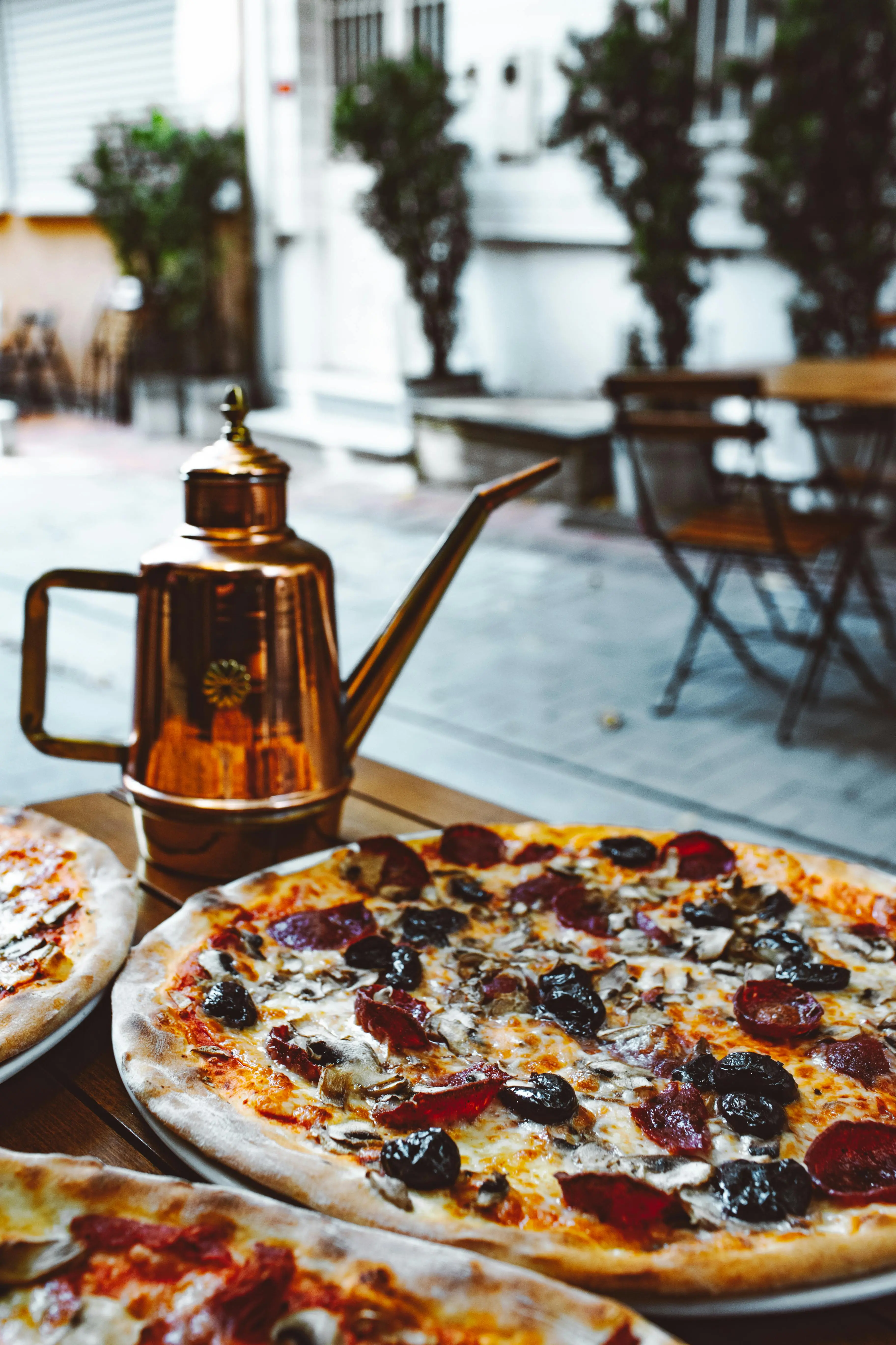 Olive oil being drizzled over hot pizza