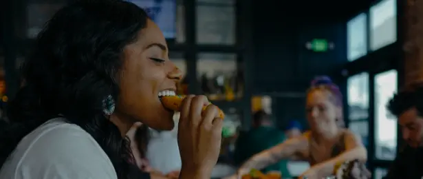 Woman eating pizza in a cozy restaurant